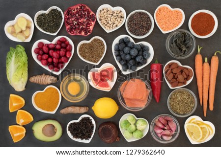 Super food to slow the ageing process concept including fish, fruit, vegetables, nuts, green & black tea, herbs, spices and dairy. High in antioxidants, anthocyanins, dietary fibre & vitamins.