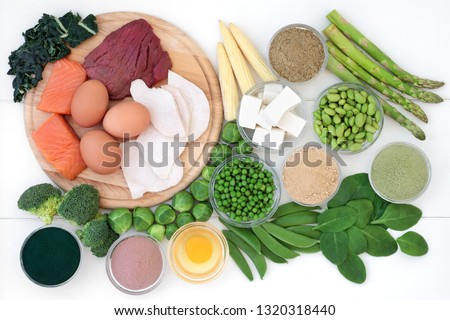 High protein food collection with meat, fish, dairy, legumes, supplement powders and soy bean curd. Hgh in dietary fibre, antioxidants and vitamins. Top view on rustic wood background.