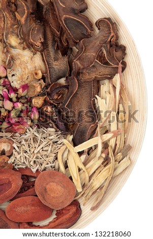 Traditional chinese herbal medicine selection on a round wooden bowl isolated over background.
