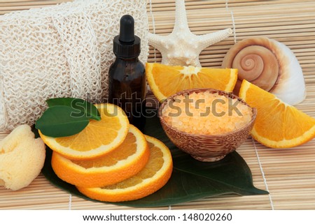 Aromatherapy essential oil with bathroom accessories, orange fruit and sea shells.