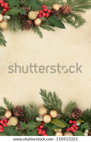 Christmas and winter border with gold baubles, natural holly, mistletoe, ivy, fir leaf sprigs and pine cones over parchment background.