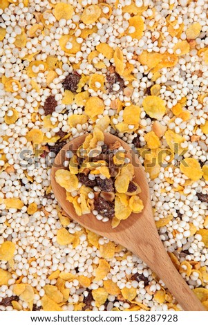 Gluten free muesli breakfast cereal in a wooden spoon and forming a background.