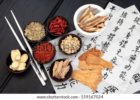 Traditional chinese herbal medicine selection with mandarin calligraphy on rice paper. Translation describes the medicinal functions to maintain body and spirit health and balance energy.