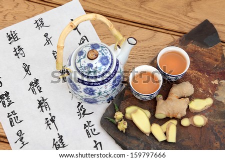 Ginger tea used in chinese herbal medicine with mandarin calligraphy on rice paper and teapot. Translation describes the medicinal functions to maintain body and spirit health and balance energy.