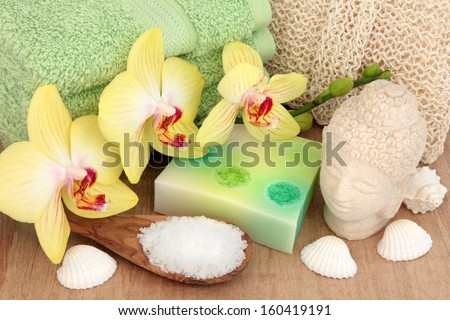 Spa and bathroom accessories with orchid flowers, sea salt, soap and exfoliating scrub.
