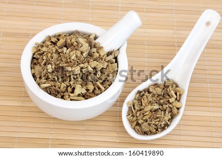Licorice herb root used in chinese herbal medicine in a mortar with pestle and spoon. Gan cao. Glycyrrhiza glabra.