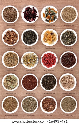 Large herb tea selection in white porcelain dishes over papyrus background with titles Large herb tea selection in white porcelain dishes over papyrus background with titles