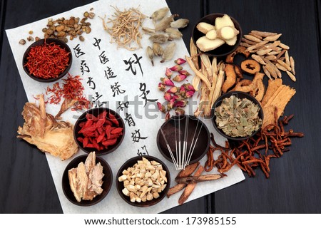 Chinese herbal medicine selection with acupuncture needles and calligraphy script on rice paper.