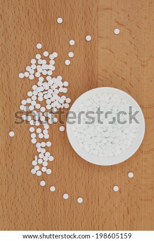 Sugar sweetener tablets on a beech wood board.