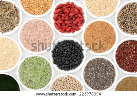 Health food and body building powders in porcelain dishes over white background.