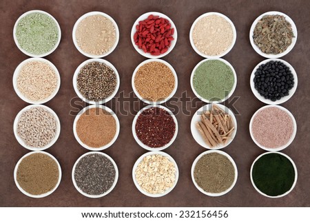 Health food and body building powders in porcelain dishes over natural lokta paper background.