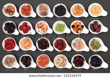 Large dried fruit selection in white bowls over slate background with titles.