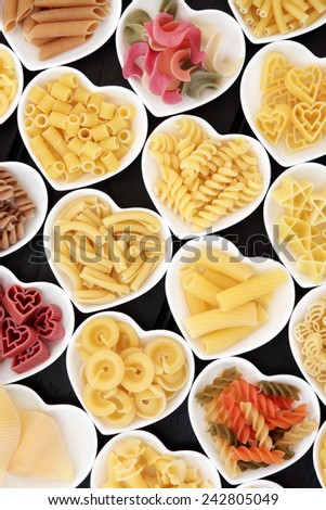 Dried pasta food selection in heart shaped porcelain dishes.