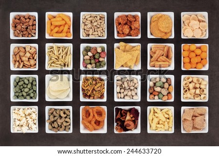 Large savoury snack food selection in square porcelain bowls.