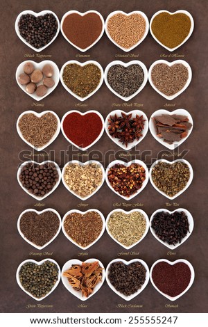 Large spice selection in heart shaped dishes over lokta paper background with titles.