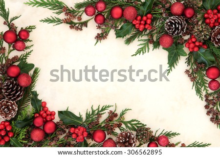 Christmas abstract background border with red bauble decorations, holly and winter greenery over old parchment paper.