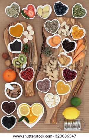 Large super food and medicinal herb selection for cold remedy with foods high in antioxidants on olive wood boards over white background.