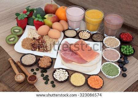 Health and body building food with fish and meat, supplement powders, vitamin tablets, pulses, nuts, vegetables, fruit and high protein and juice smoothie shakes.