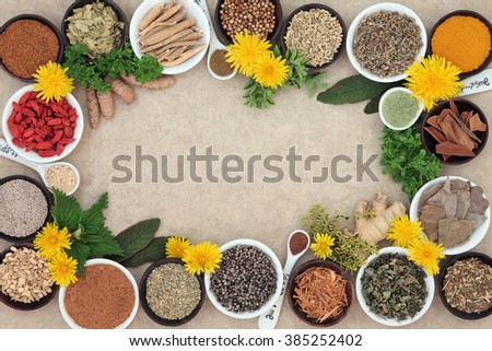 Herbal medicine selection with fresh and dried herbs and spices forming an abstract background on natural hemp paper.