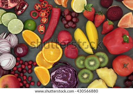 Healthy fresh fruit and vegetable superfood background on slate, high in antioxidants, anthocyanins, vitamins, dietary fiber and minerals.