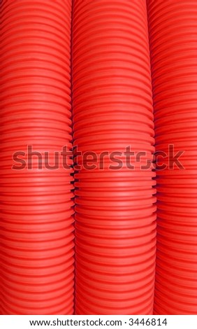 Abstract of three lengths of red drainage pipe on a vertical axis.