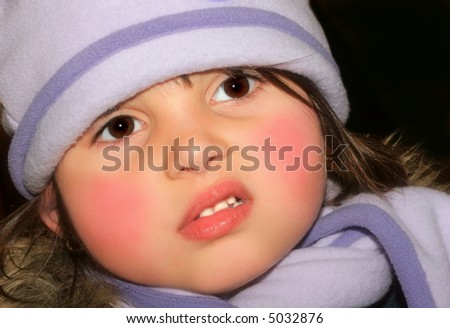 Face of a little girl with rosy cheeks wearing a lilac scarf and hat with a puzzled look on her face.