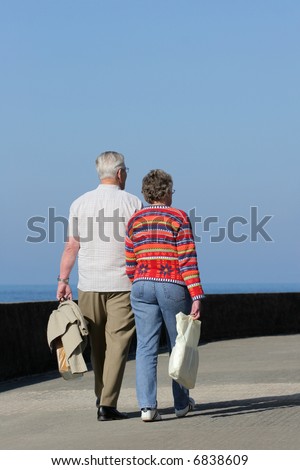 Two elderly people walking together 