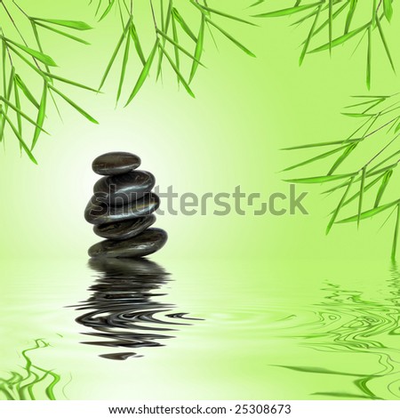 Zen garden abstract of black spa massage stones in perfect balance with bamboo leaf grass and  reflection over rippled water, against green background with a white glow.