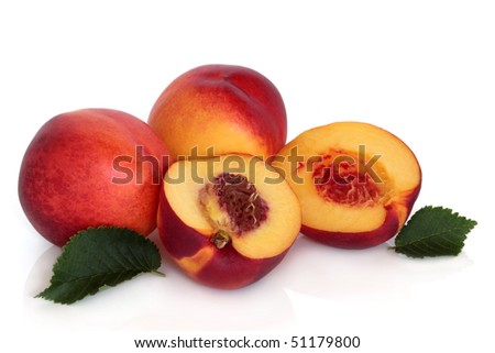 Nectarine fruit whole and in halves with leaf sprigs, isolated over white background with reflection.