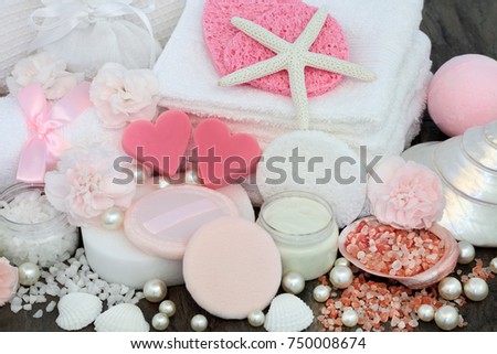 Skincare and body care beauty treatment including pink heart shaped soaps, himalayan exfoliating salt, sponges, face cloths, moisturizing lotion, powder puffs, and carnation flowers.