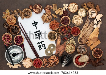 Chinese medicine with herb selection,  acupuncture needles, moxa sticks used in moxibustion therapy and calligraphy script  and feng shui coins. Translation reads as Chinese alternative medicine.