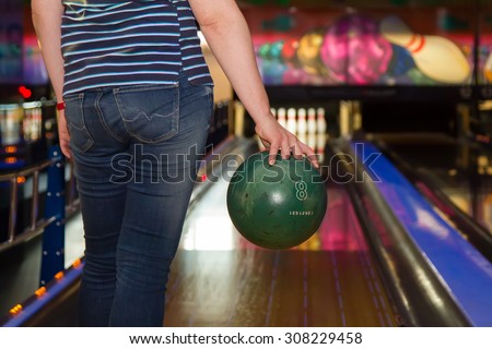Close up of woman holding a bowling ball at the bowling club, rear view