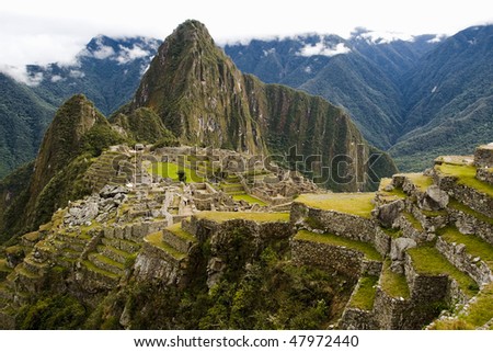 a view of Machu Picchu with a thick cloud cover in the distance.