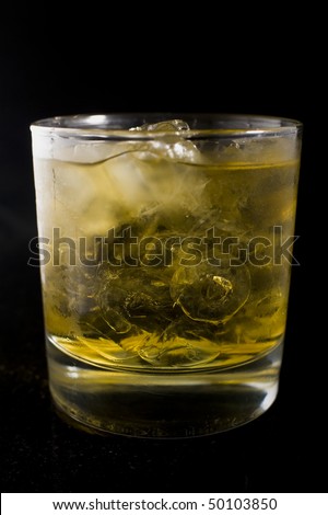 an icy cold beverage meant to resemble scotch or whiskey sitting on black granite.