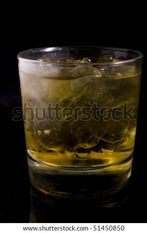 an icy cold beverage meant to resemble scotch or whiskey sitting on black granite.