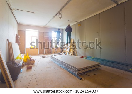 Workers are installing plasterboard (drywall) for gypsum walls in apartment is under construction, remodeling, renovation, extension, restoration and reconstruction.