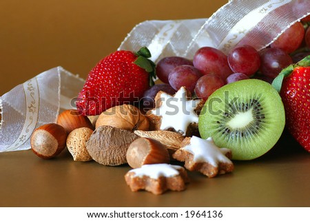 A selection of fruit, nuts and cookies on gold background