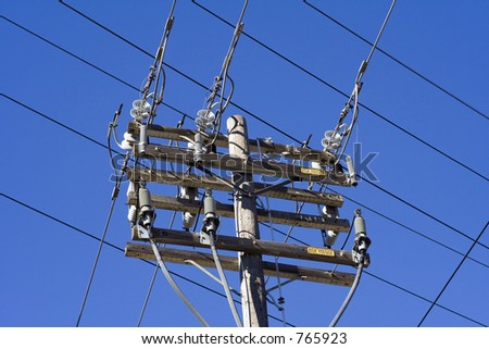 Power lines run in perpendicular paths around a power pole