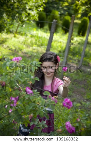 Little girl picking  roses for perfumes and rose oil in the garden
