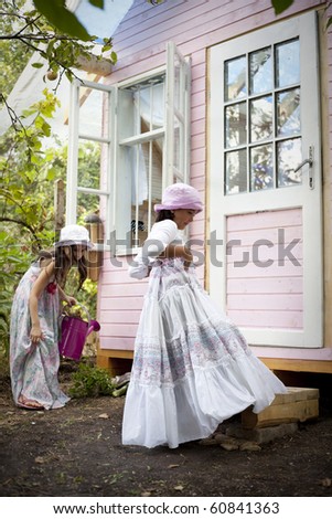 Sweet little girls in front of him little house for playtime