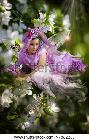 Little fairy girl on the blossom cherry branch