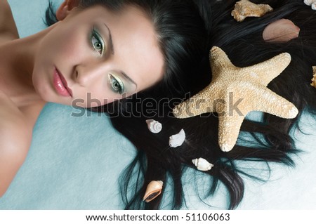 Beauty brunette with sea shells in hair