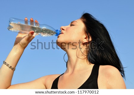 Thirst. Young woman drinking cold water in hot day