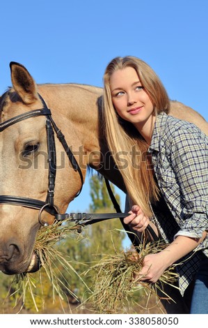 teenage girl feeding horse in sunny day