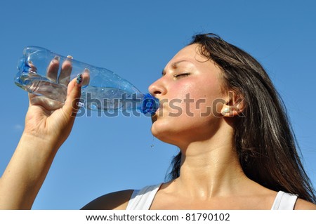 young athletic woman drinking cold water in hot day