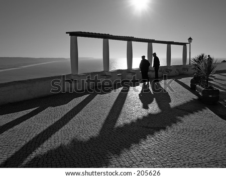 in nazare, two old men talking in the winter sun