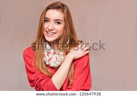 girl with brace smiling, holding her arm