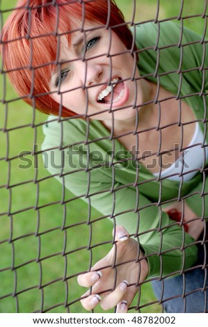 Young woman trapped in a cage screaming for help.