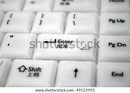 A white computer keyboard with multi language.