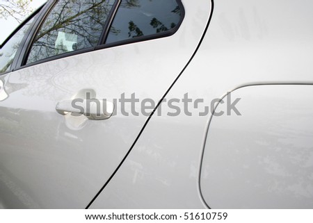 A view of white car rear door and window.